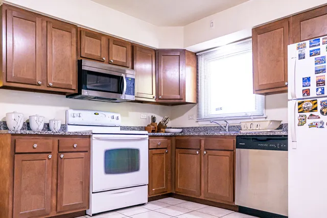 a kitchen with granite countertop cabinets stainless steel appliances and a window