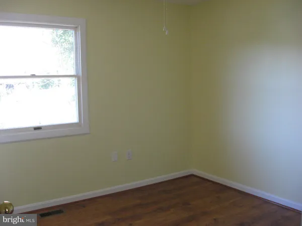 a view of a small space with wooden floor and a window