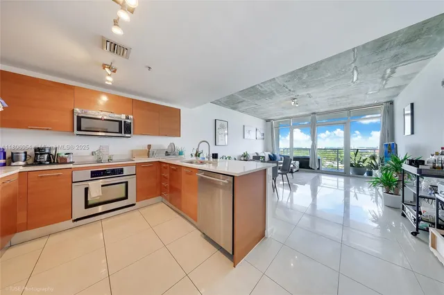 a kitchen with stainless steel appliances granite countertop a sink counter space and chairs in it
