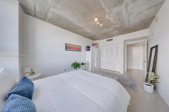 a bedroom with a large bed and a window