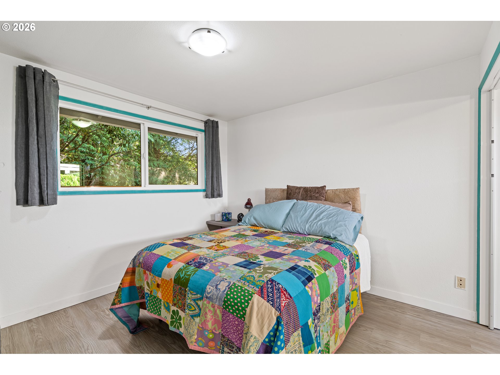 214 Northwest Seblar Drive Portland, OR 97210 - Photo 22 of 36 a bedroom with a bed that has a blanket on it and next to a window