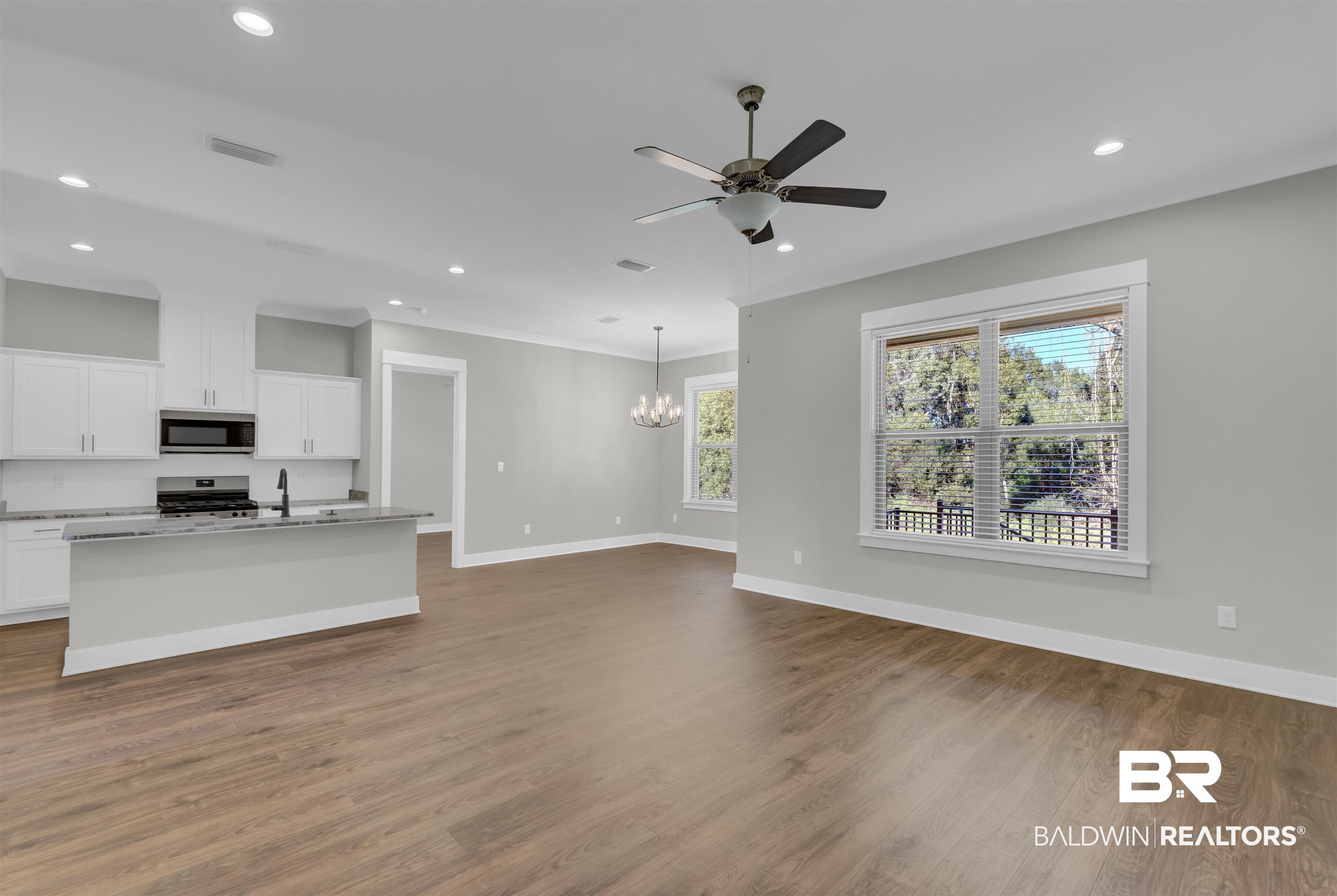 571 Morning Mist Way Fairhope, AL 36532 - Photo 10 of 47 Unfurnished living room featuring a chandelier, recessed lighting, dark wood finished floors, a ceiling fan, and ornamental molding