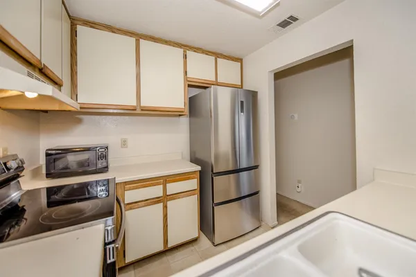 a kitchen with stainless steel appliances granite countertop a refrigerator and a stove