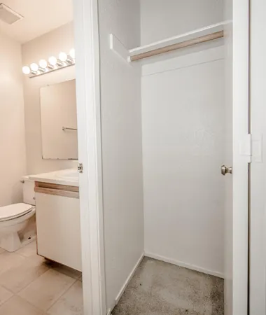 a bathroom with a granite countertop sink a toilet and a mirror