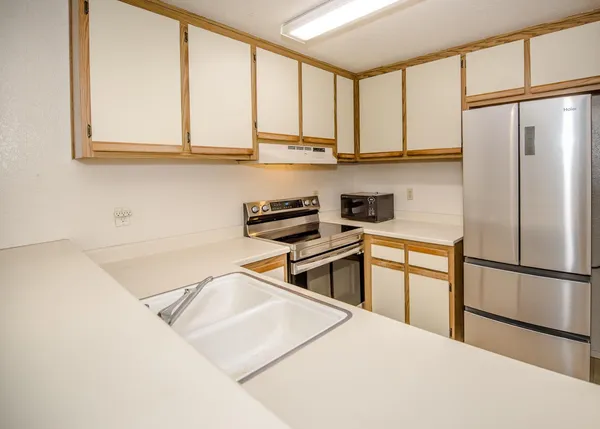 a kitchen with stainless steel appliances granite countertop a refrigerator sink and cabinets