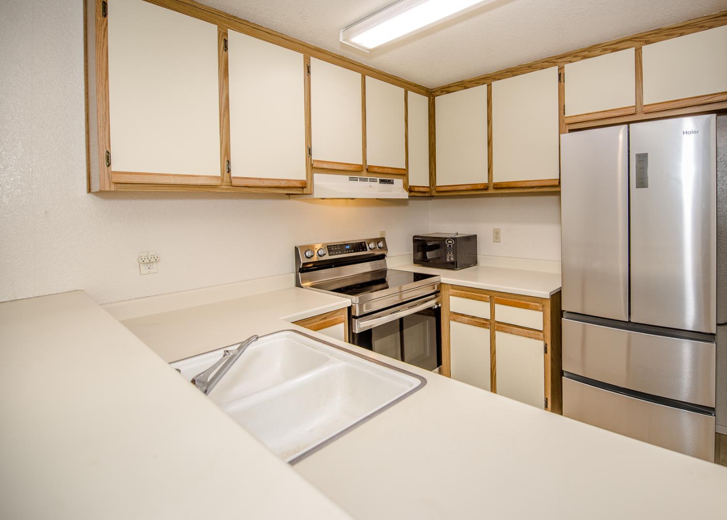 1019 Dornajo Way, Unit 244 Sacramento, CA 95825 - Photo 9 of 41 a kitchen with stainless steel appliances granite countertop a refrigerator sink and cabinets