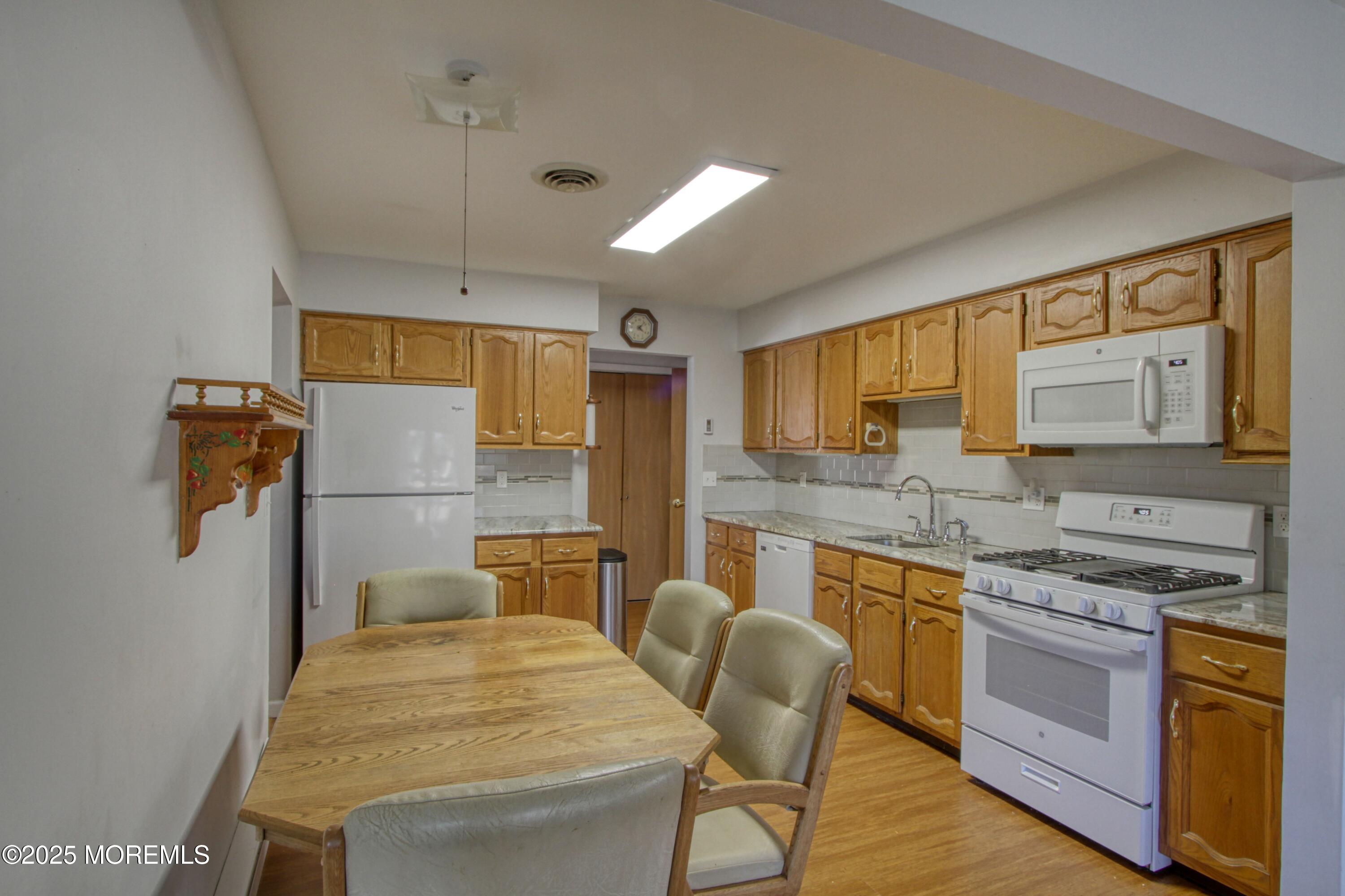 19 Amesbury Road Whiting, NJ 08759 - Photo 2 of 26 a kitchen with a table chairs refrigerator and cabinets