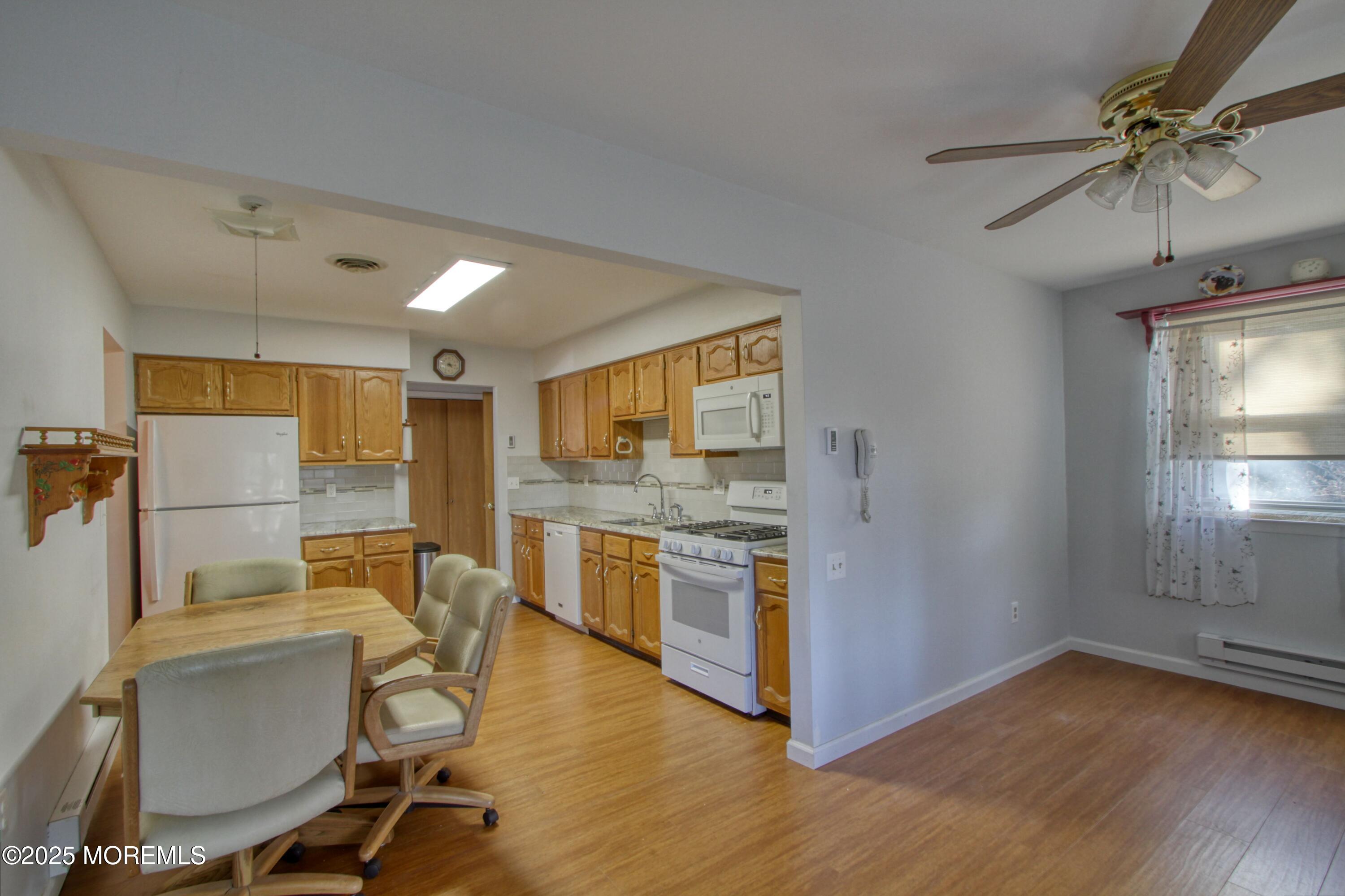 19 Amesbury Road Whiting, NJ 08759 - Photo 4 of 26 a view of a kitchen with furniture a ceiling fan and wooden floor