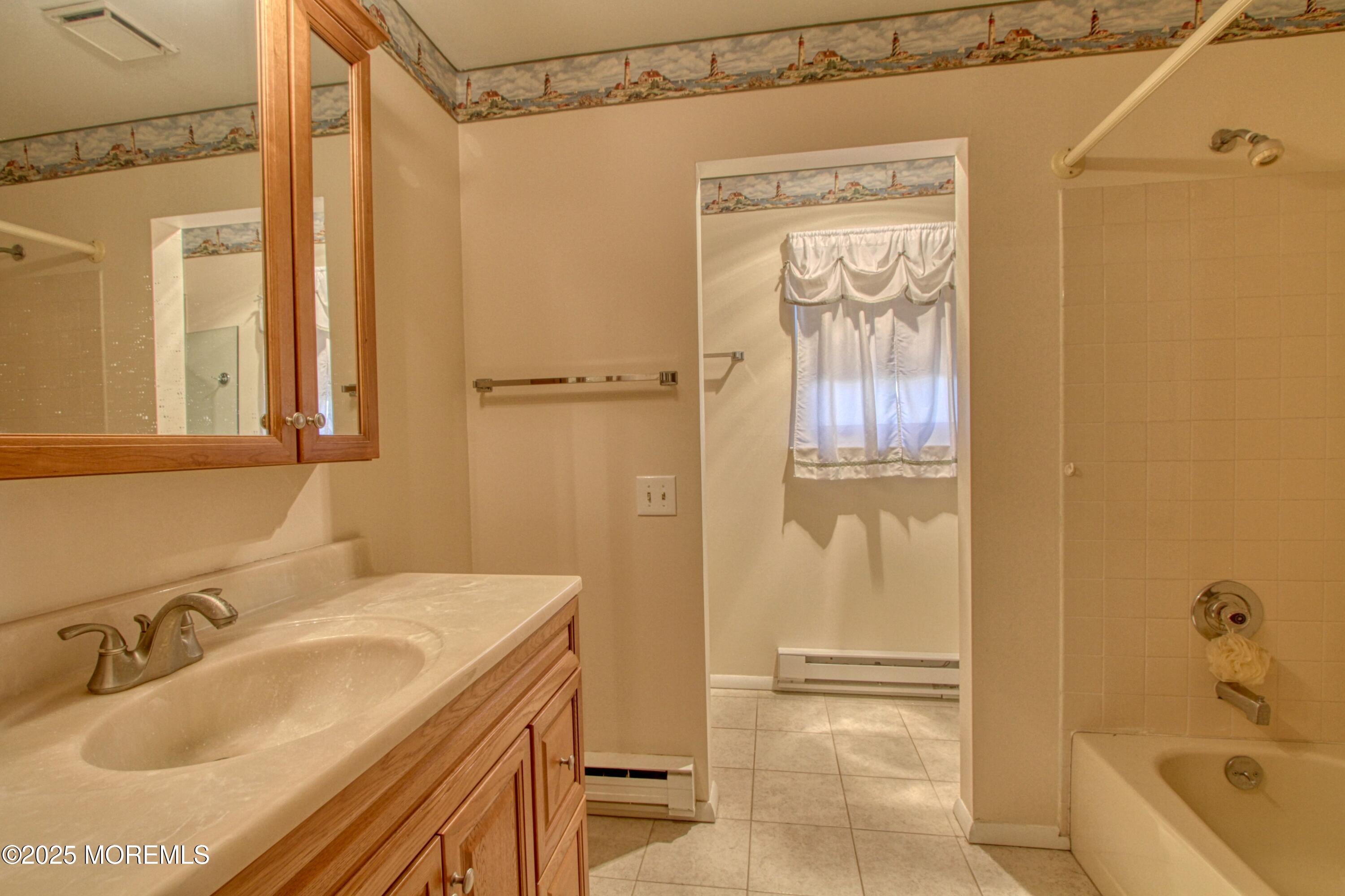 19 Amesbury Road Whiting, NJ 08759 - Photo 10 of 26 a bathroom with a granite countertop sink a mirror and a bathtub