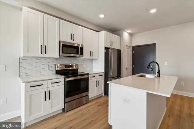 a kitchen with stainless steel appliances a stove microwave and refrigerator
