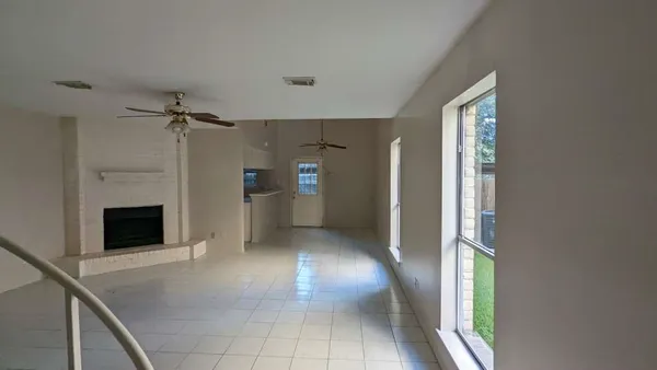 a view of a hallway with an entryway and a fireplace