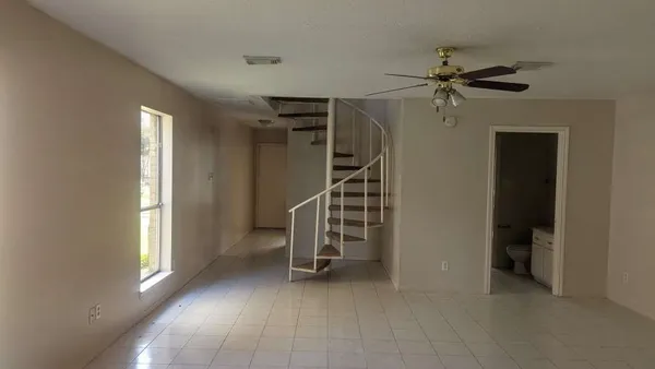 a view of empty room with stairs and wooden floor