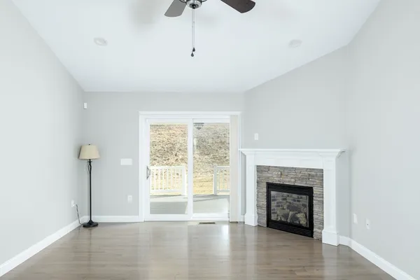 a view of an empty room with a window and fireplace