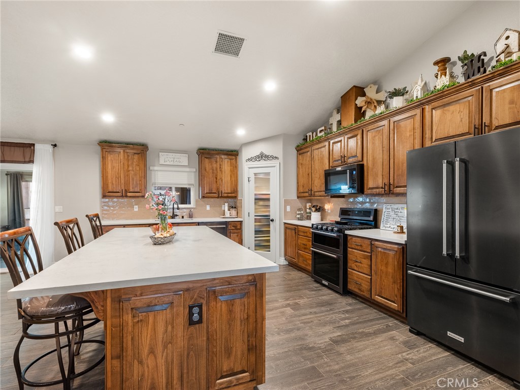 15620 Erie Road Apple Valley, CA 92307 - Photo 17 of 53 a kitchen with stainless steel appliances granite countertop a kitchen island hardwood floor sink stove and granite counter top
