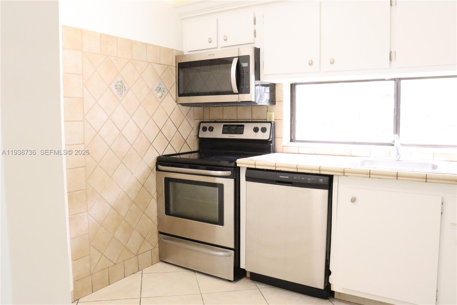 16919 North Bay Road, Unit 118 Sunny Isles Beach, FL 33160 - Photo 3 of 20 a kitchen with stainless steel appliances a stove microwave and sink