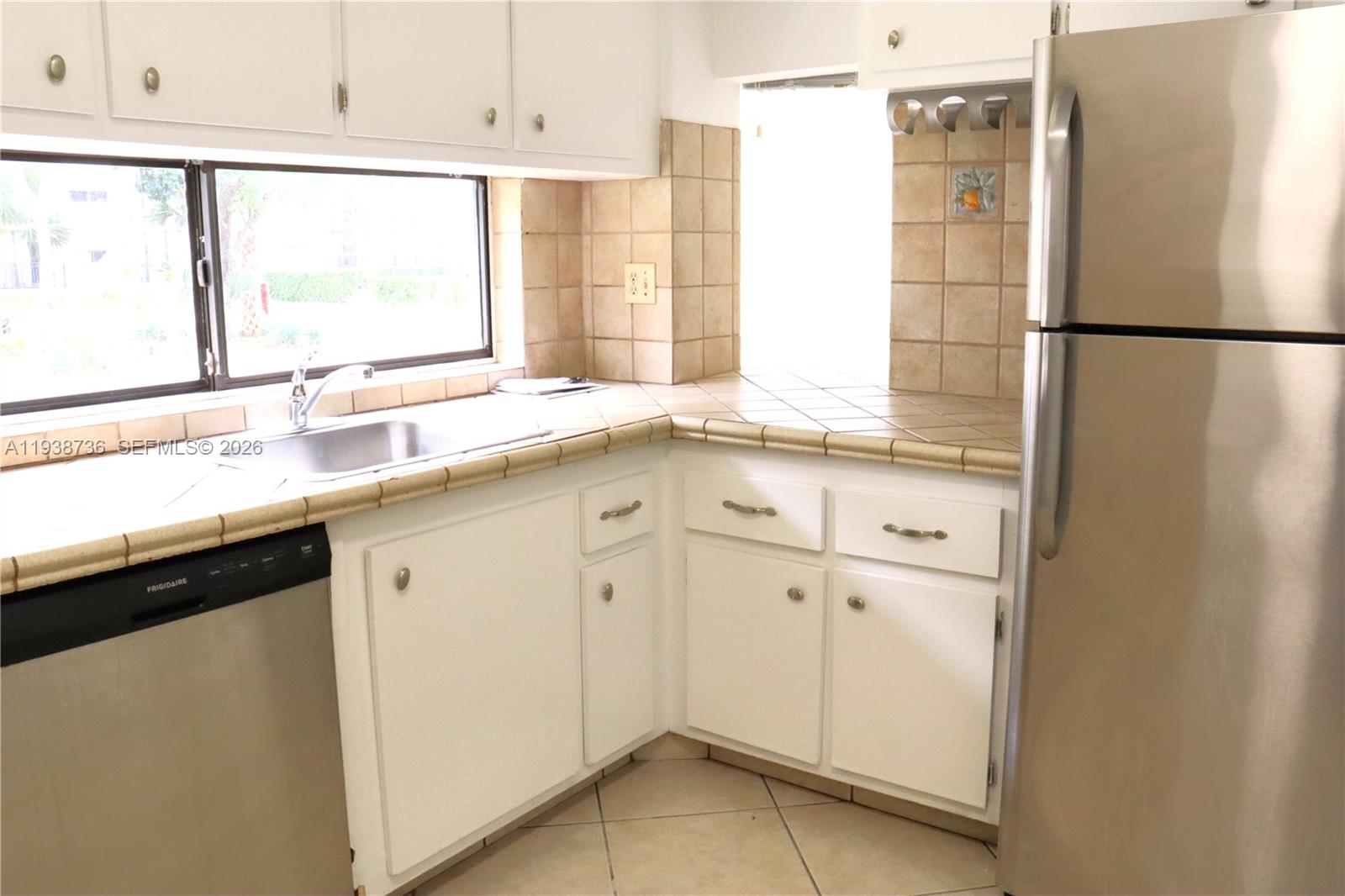 16919 North Bay Road, Unit 118 Sunny Isles Beach, FL 33160 - Photo 4 of 20 a kitchen with a sink and a refrigerator