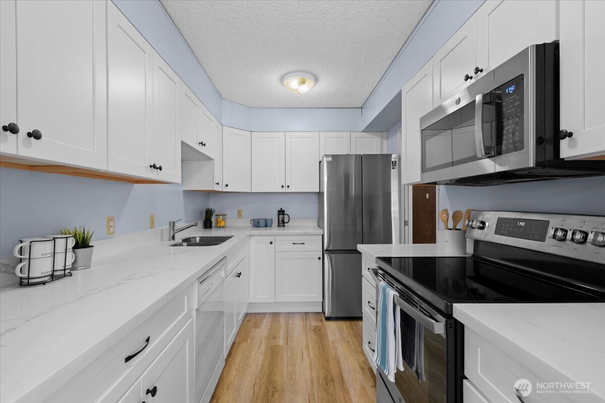2100 3rd Avenue, Unit 2505 Seattle, WA 98121 - Photo 11 of 40 a kitchen with a sink a stove and refrigerator
