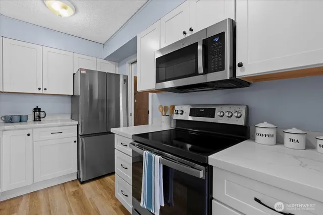 a kitchen with stainless steel appliances a stove microwave and refrigerator