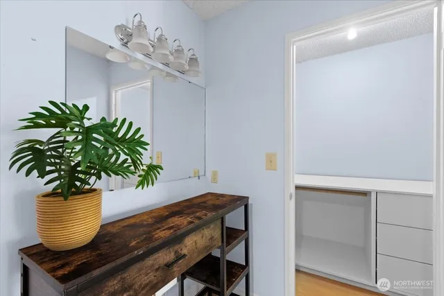 a vase of flowers sitting on a table with a potted plant