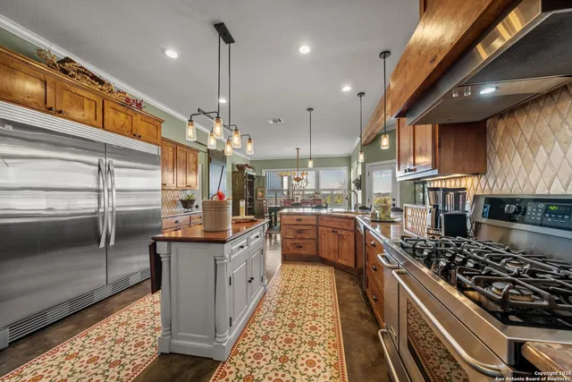 a kitchen with stainless steel appliances kitchen island granite countertop a stove and cabinets
