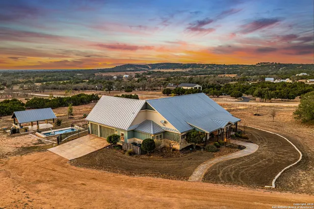 an aerial view of a house with yard swimming pool and ocean view