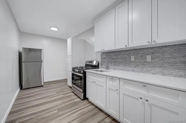 a kitchen with white cabinets and stainless steel appliances