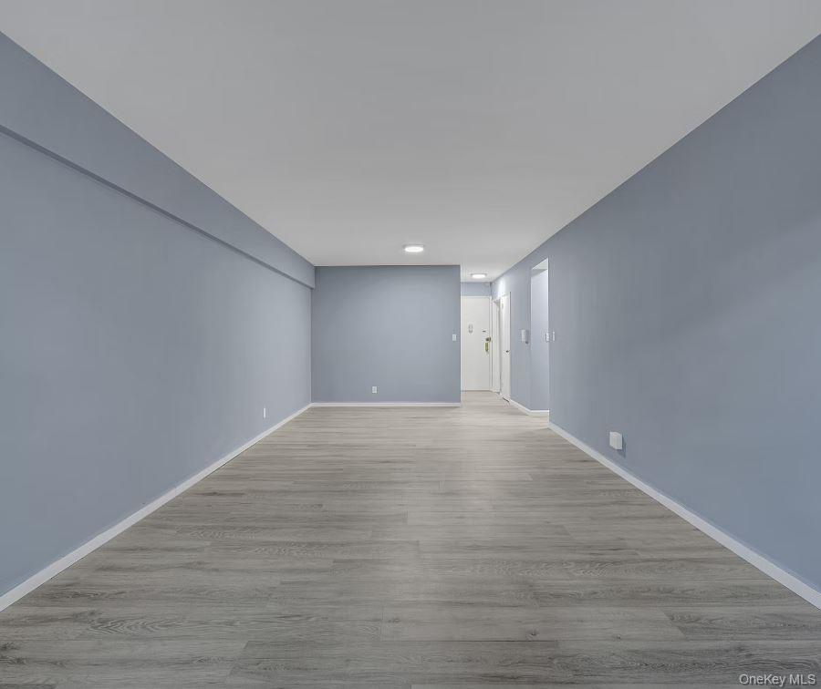609 Palmer Road, Unit 3M Yonkers, NY 10701 - Photo 3 of 18 View from the far end of the living and dining area facing the unit's front entrance with light wood-style flooring and baseboards