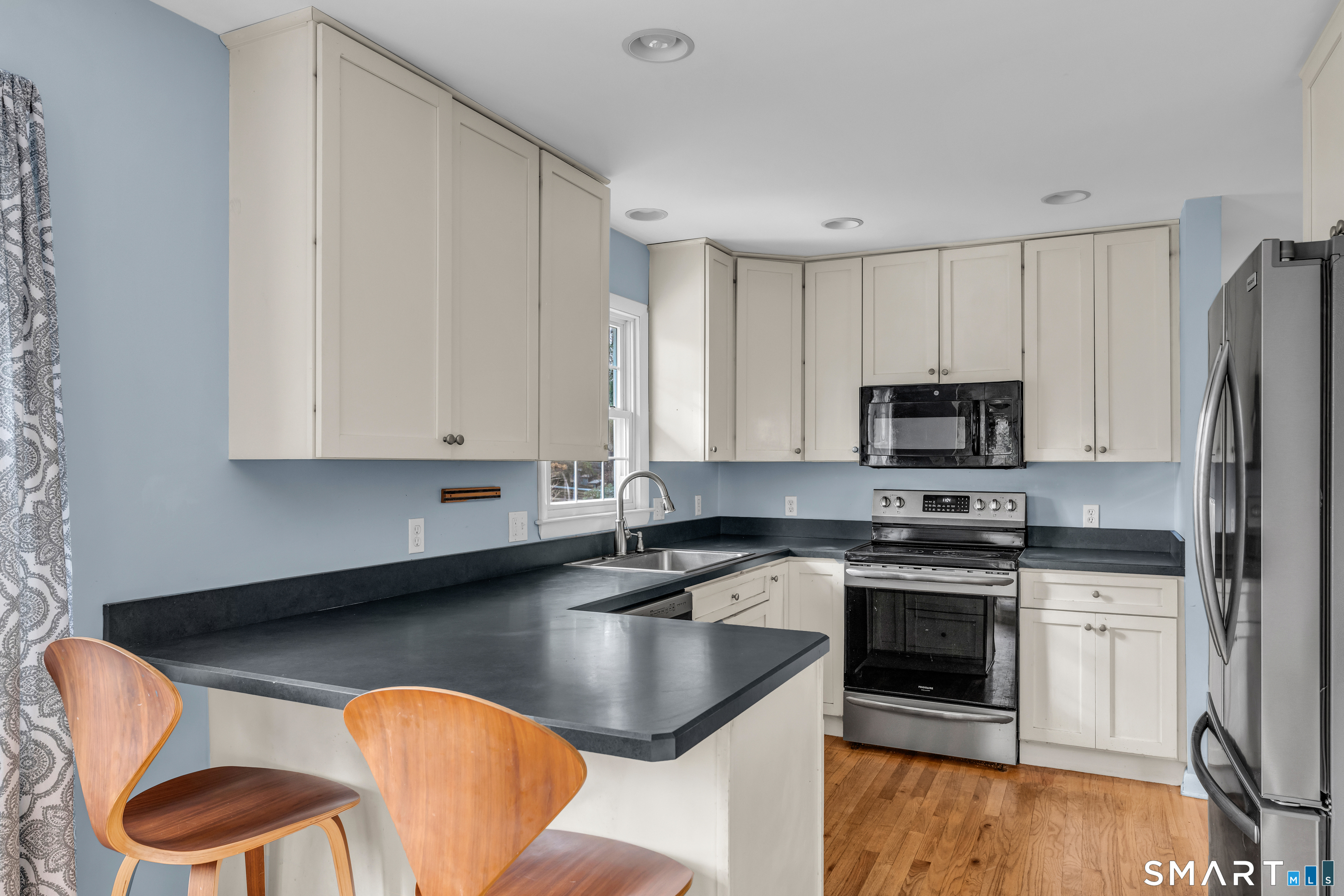 43 Fort Path Road Madison, CT 06443 - Photo 14 of 40 a kitchen with stainless steel appliances granite countertop a sink a stove a refrigerator cabinets and a dining table