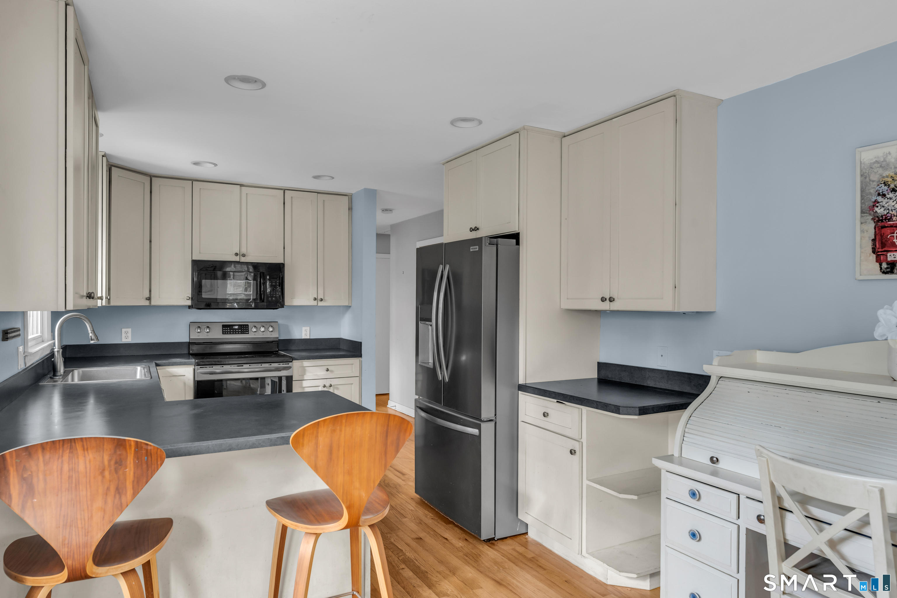 43 Fort Path Road Madison, CT 06443 - Photo 15 of 40 a kitchen with stainless steel appliances granite countertop a refrigerator a stove a sink dishwasher and white cabinets with wooden floor