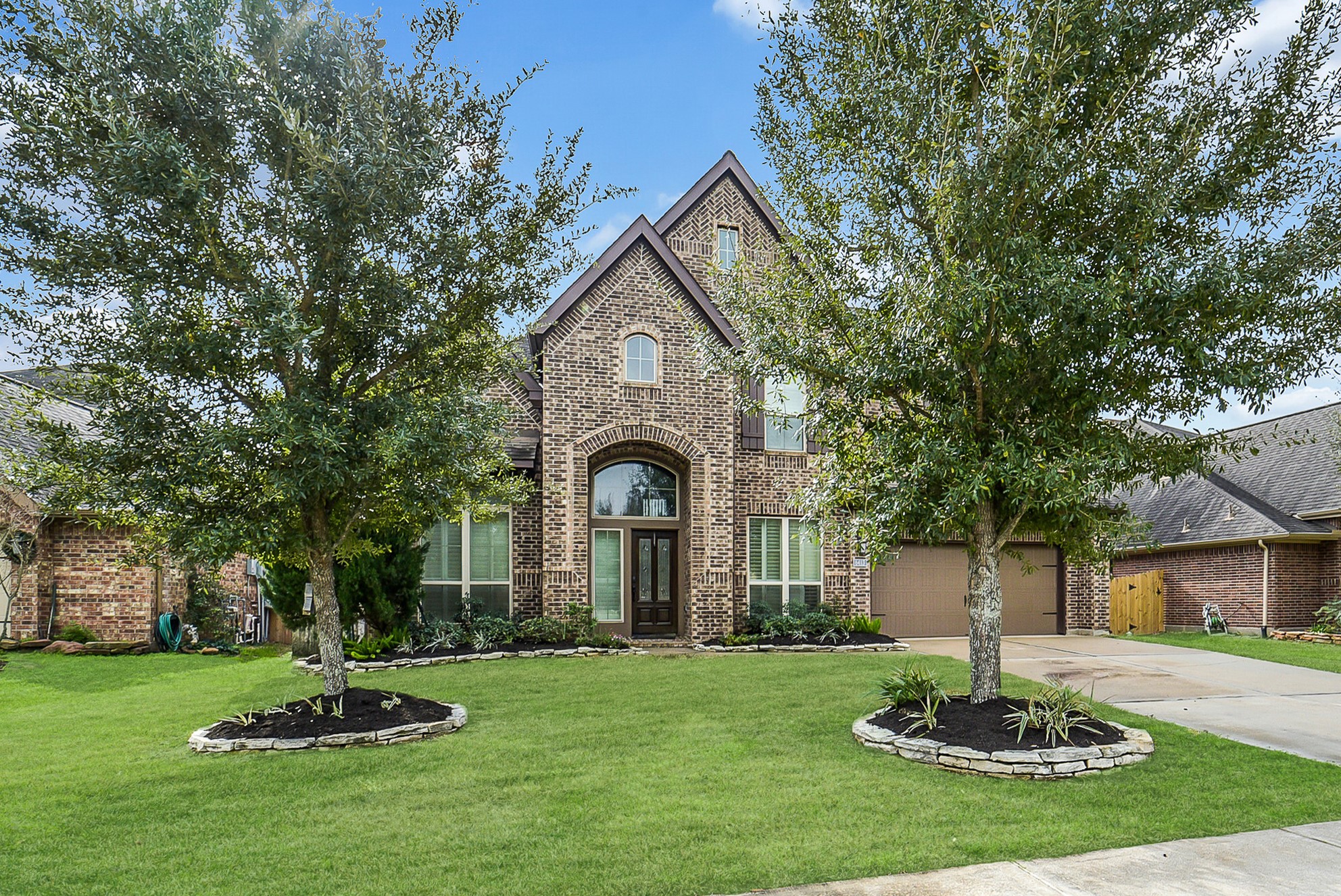 6413 Delta Crossing Court Rosenberg, TX 77471 - Photo 2 of 46 a front view of a house with a garden and trees