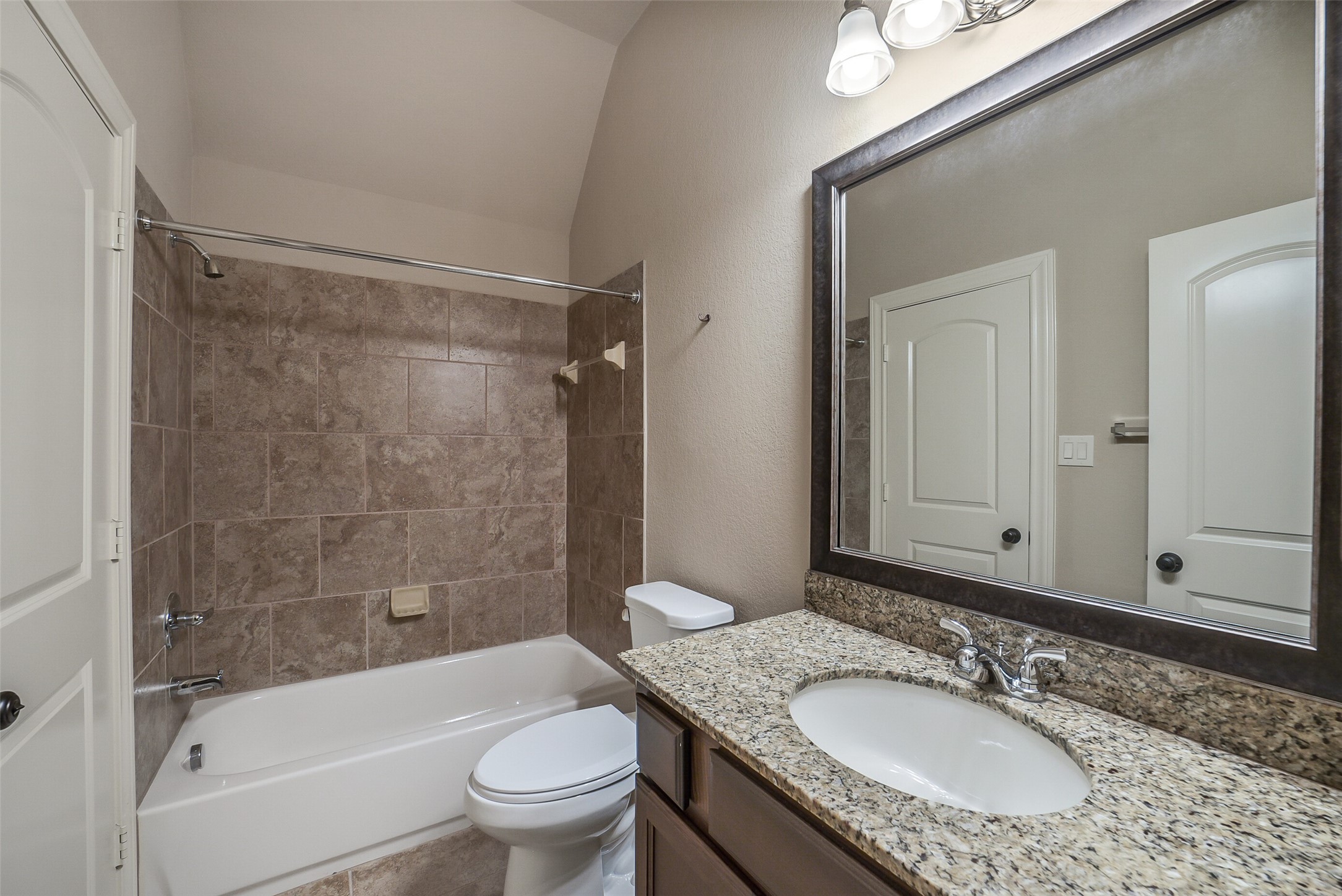 6413 Delta Crossing Court Rosenberg, TX 77471 - Photo 33 of 46 a bathroom with a granite countertop sink toilet mirror and shower
