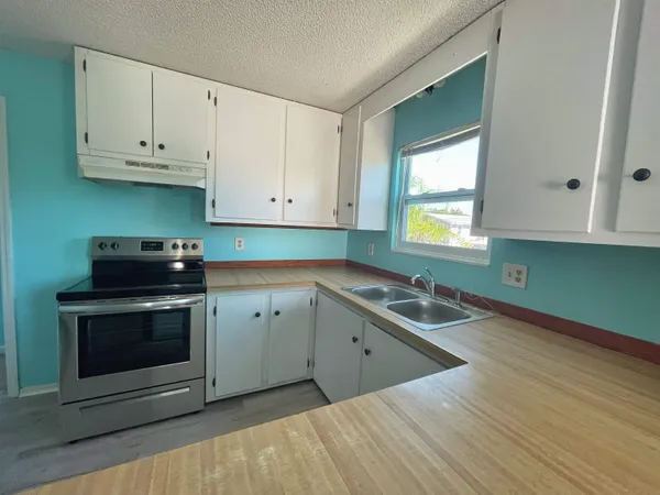 an empty room with a window and wall fan