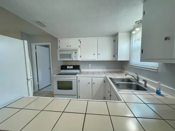 a kitchen with a refrigerator sink and cabinets