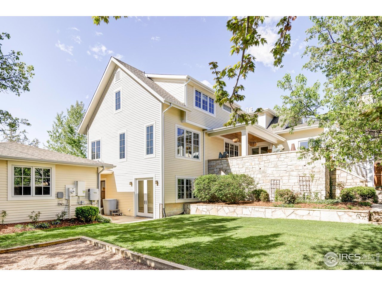3132 5th Street Boulder, CO 80304 - Photo 20 of 27 a view of a white house next to a yard with big trees