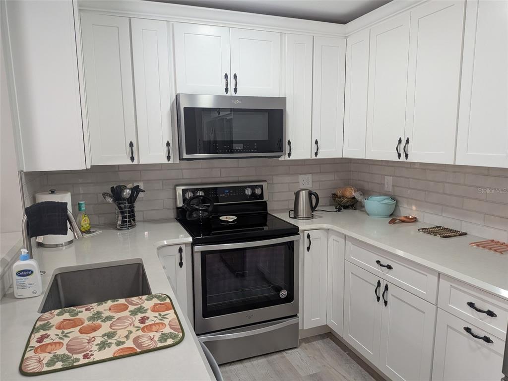 700 Starkey Road, Unit 821 Largo, FL 33771 - Photo 11 of 29 a kitchen with stainless steel appliances granite countertop a sink stove and cabinets