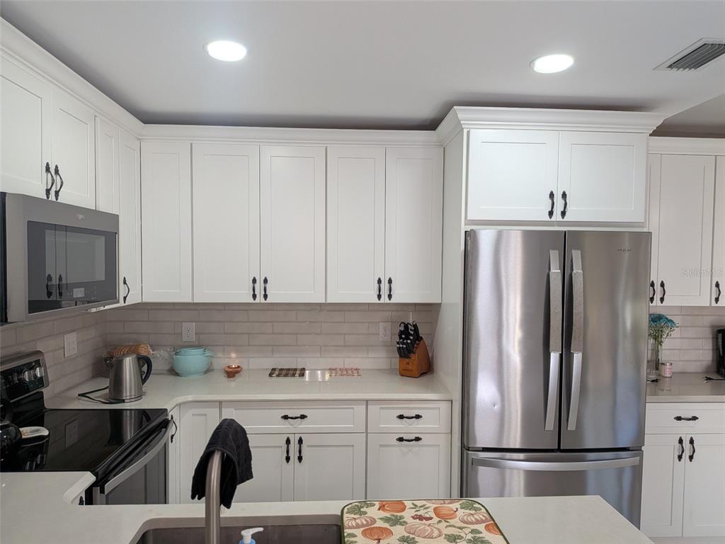 700 Starkey Road, Unit 821 Largo, FL 33771 - Photo 7 of 29 a kitchen with stainless steel appliances a refrigerator sink and cabinets
