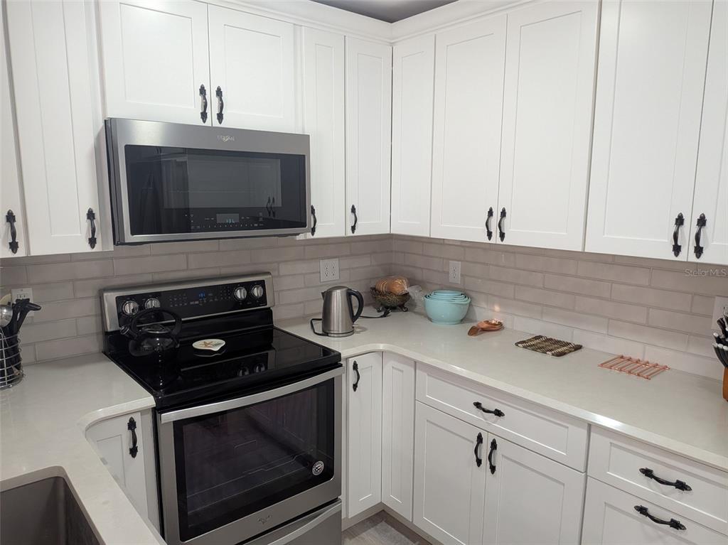 700 Starkey Road, Unit 821 Largo, FL 33771 - Photo 10 of 29 a kitchen with a stove microwave and cabinets