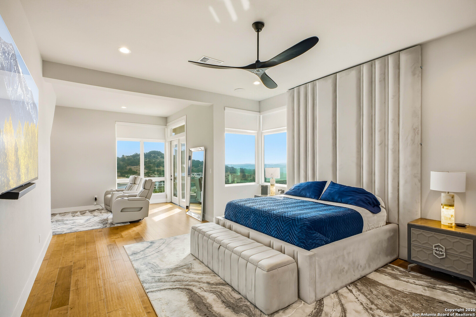 23315 Ebner Ridge San Antonio, TX 78255 - Photo 33 of 103 a spacious bedroom with a large bed and a chandelier