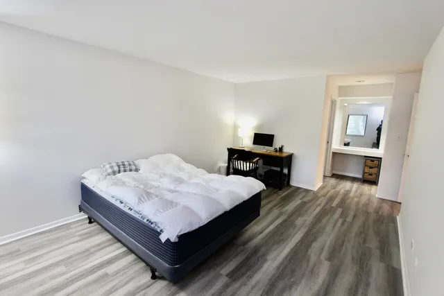 a room with a bed and wooden floor