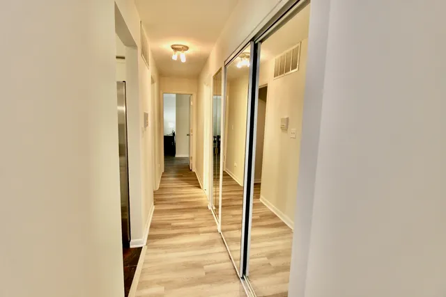 a view of a hallway with wooden floor and staircase