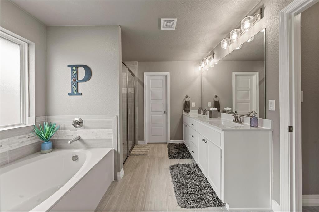 828 Agile Street Hewitt, TX 76643 - Photo 23 of 30 a bathroom with a tub a sink and a large mirror