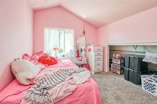 a bedroom with a bed a dresser and a chandelier
