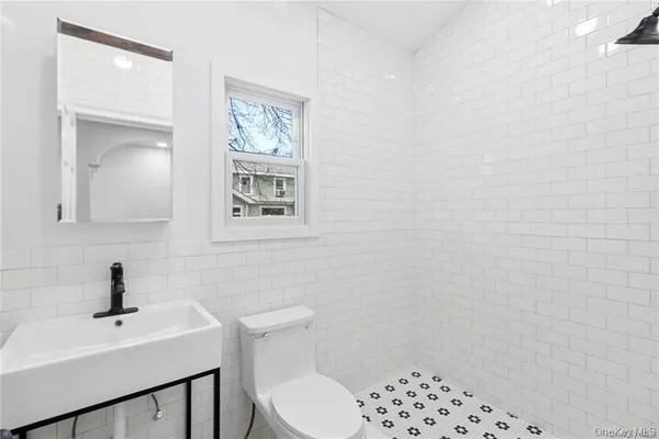 a bathroom with a toilet a sink and mirror