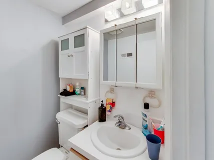 a bathroom with a sink toilet and mirror