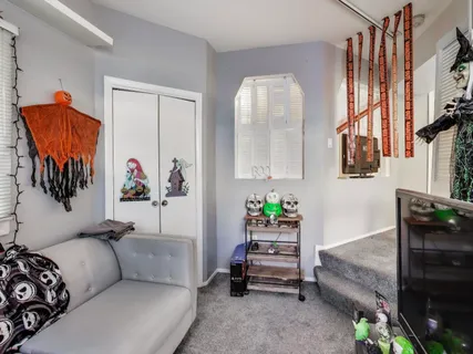 a living room with furniture and a painting on the wall