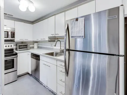 a kitchen with stainless steel appliances a refrigerator sink and cabinets