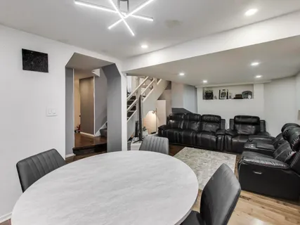 a large bedroom with bed couches and wooden floor