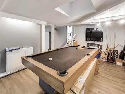 a living room with stainless steel appliances furniture and flat screen tv
