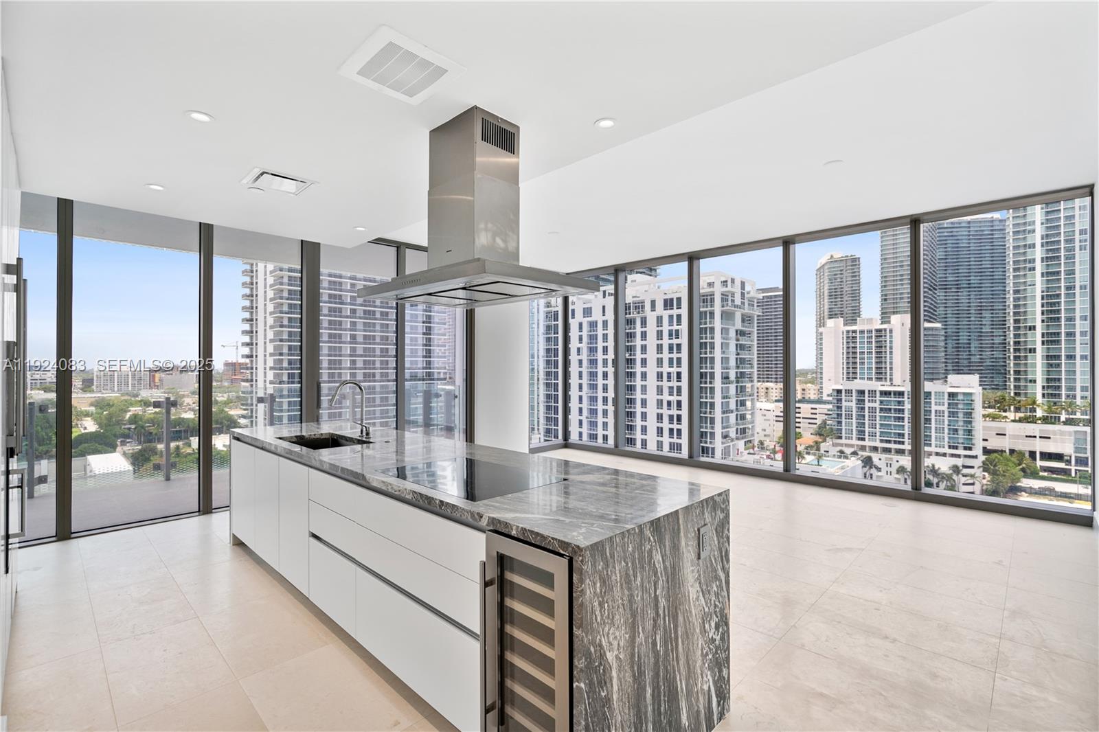 a large white kitchen with granite countertop a large window and a sink