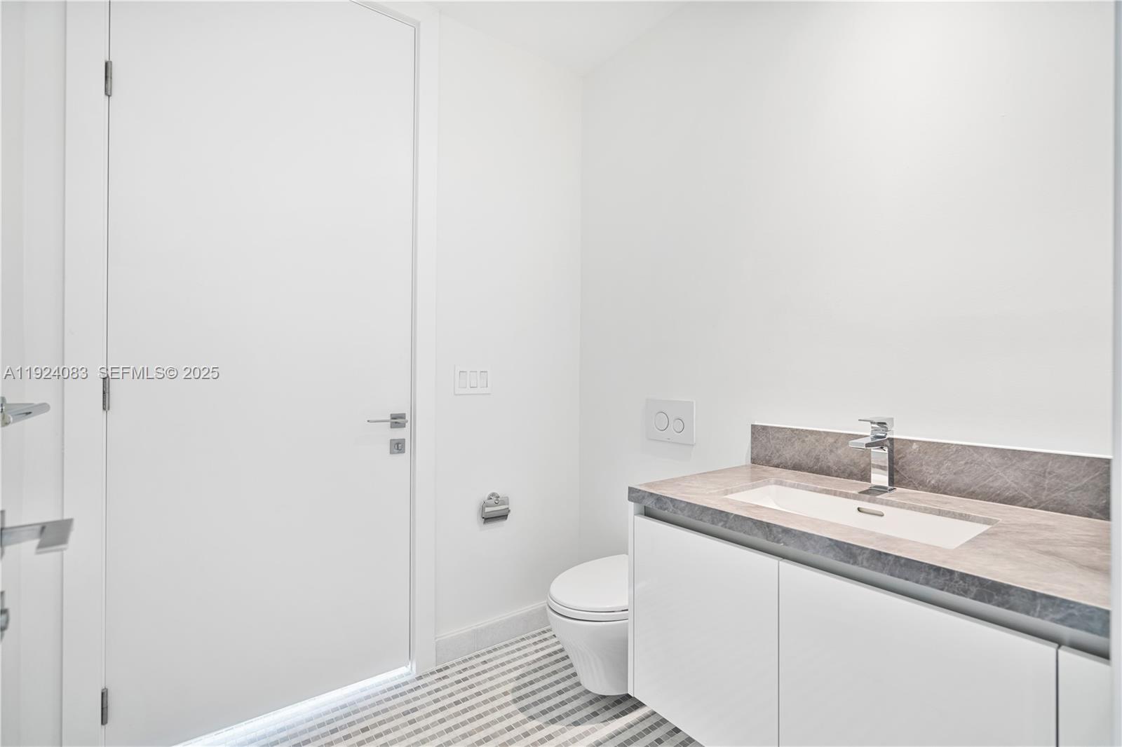 700 Northeast 26th Terrace, Unit 1406 Miami, FL 33137 - Photo 21 of 41 a bathroom with a granite countertop sink and a toilet